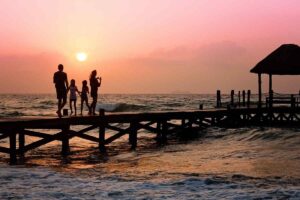 Famiglia che cammina su un pontile in riva al mare