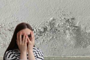 umidità e donna che si copre occhi